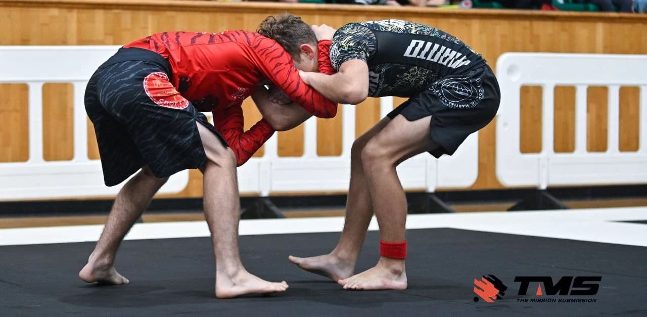 Двоє спортсменів Avangard Jiu-Jitsu борються у стійці на змагальному татамі